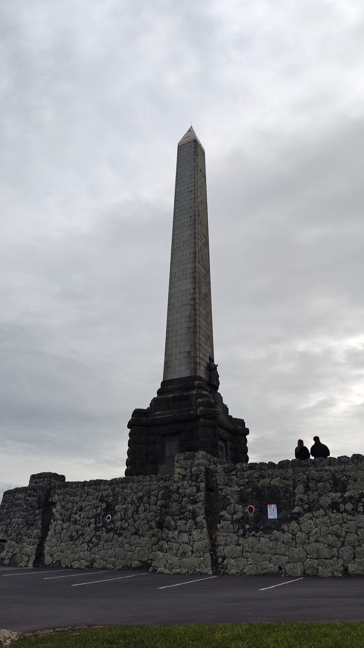 Visitors resting at the obelisk base