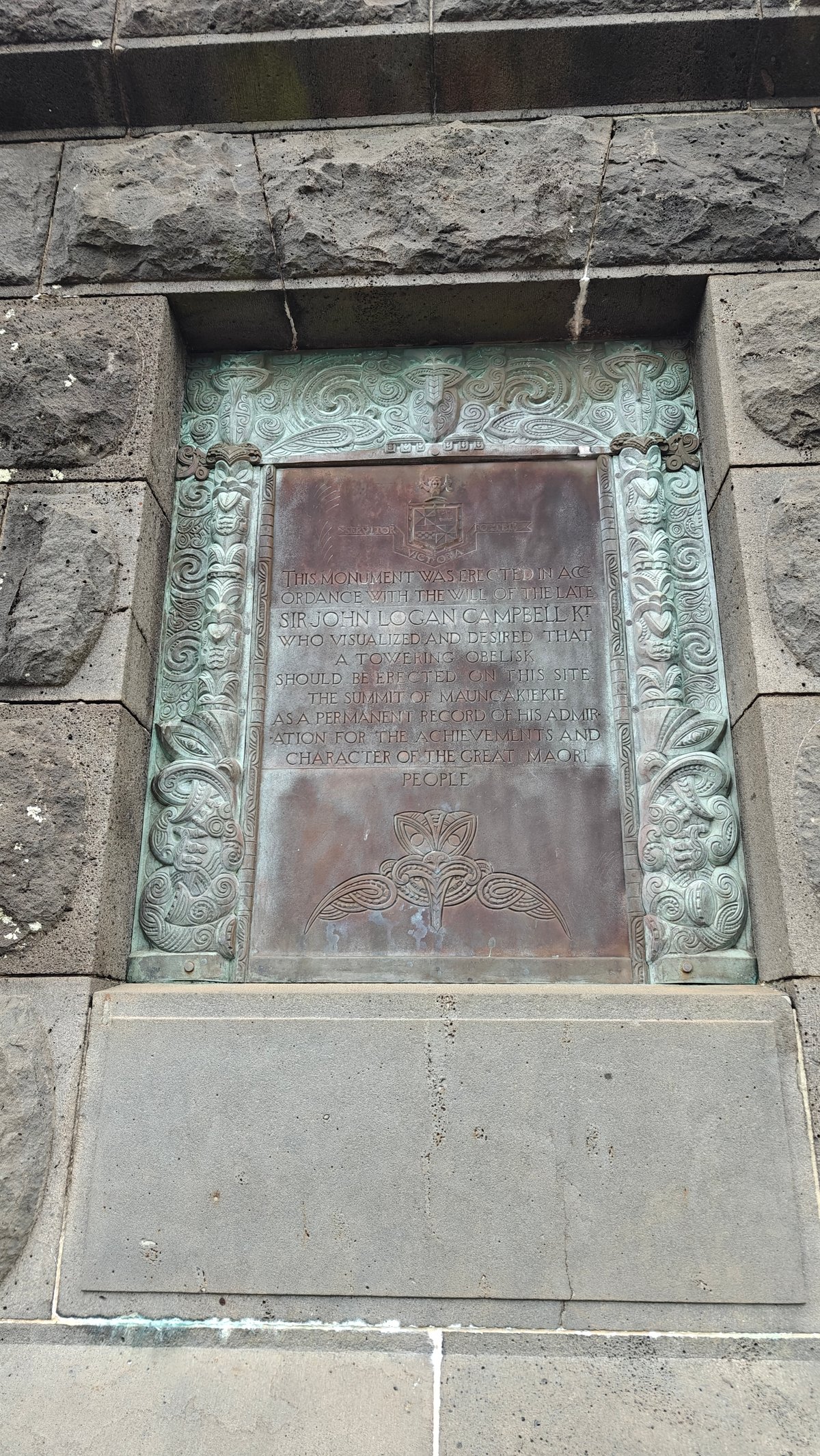 Weathered bronze plaque on the plinth